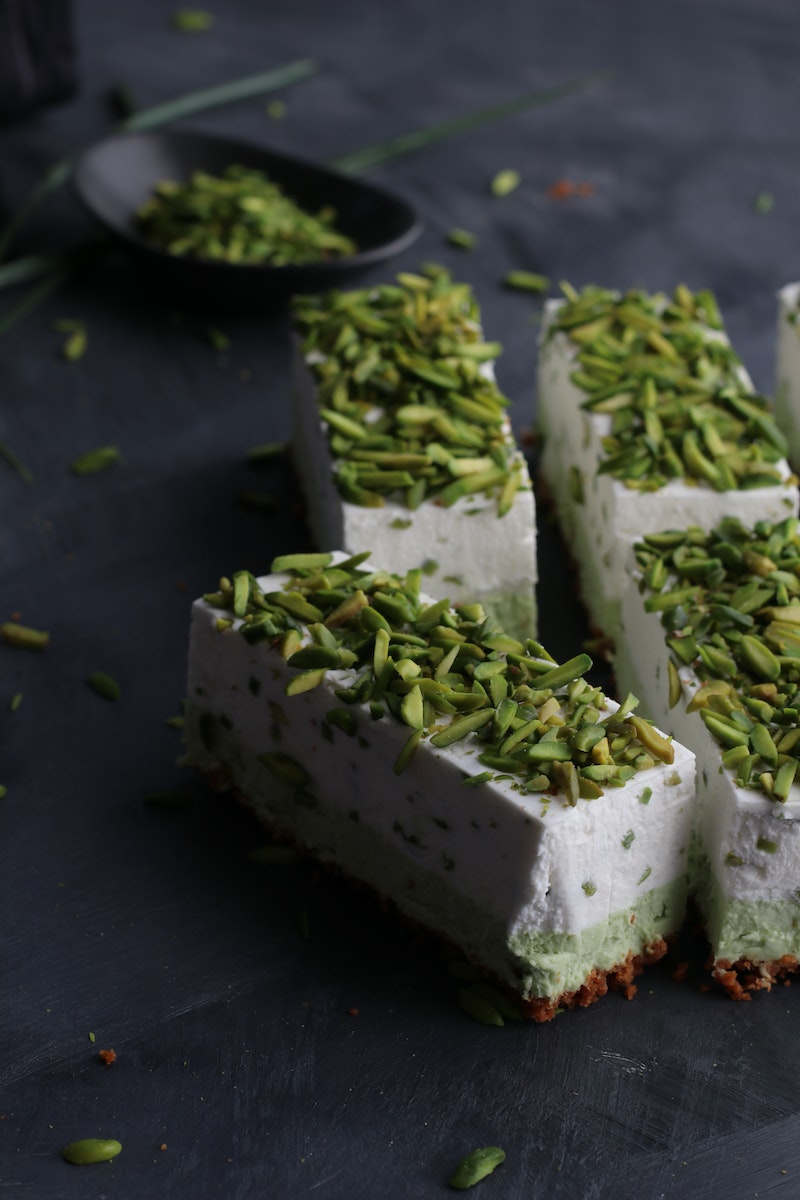 From above of similar delicious cake pieces with tender texture decorated with bright crunchy pistachios