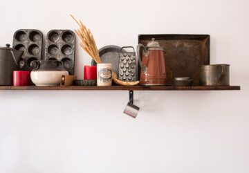 kitchen utensil lot on brown wooden floating shelf