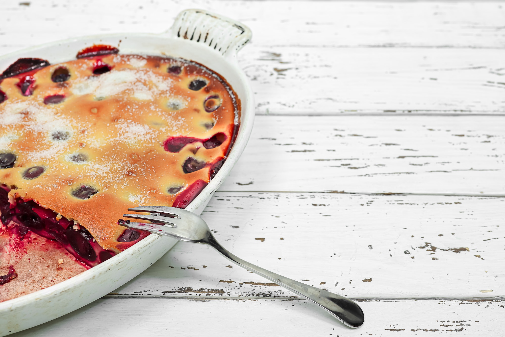 Clafoutis - traditional french cherry pie in a white baking dish